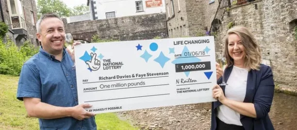 Lottery winners holding a large prize cheque